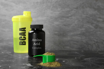 Shaker with abbreviation BCAA, Amino Acid complex in plastic jar and powder on table. Space for text