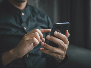 Businessman using a smartphone to view the stock market.Close-up image of male hands using smartphone at home.social networks concept.Concept of young people working mobile devices.