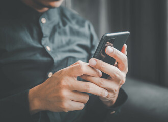 Businessman using a smartphone to view the stock market.Close-up image of male hands using smartphone at home.social networks concept.Concept of young people working mobile devices.