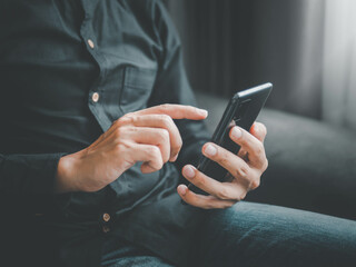 Businessman using a smartphone to view the stock market.Close-up image of male hands using smartphone at home.social networks concept.Concept of young people working mobile devices.