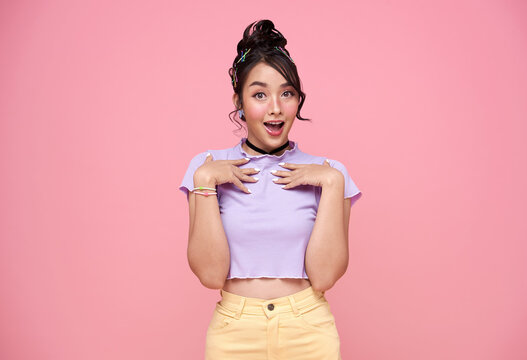 Young Asian teenage girl surprised excited isolated on pink background..
