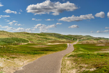 Fototapeta na wymiar Wanderweg auf dem Deich zur Nordsee mit Wolken am Himmel bei Julianadorp aan Zee, Den Helder, Nordholland, Niederlande