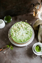 Layered cake with white chocolate and matcha tea. Mousse dessert in a light dish on a dark table.