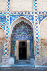 Antique wooden doors in a brick wall decorated with mosaics in the Gur Emir mausoleum in Samarkand, Uzbekistan. 29.04.2019