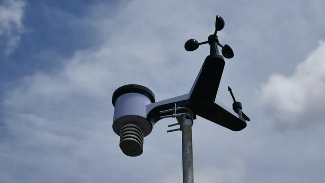 solar weather station for meteorological research with indicator wind speed rain gauge temperature control bottom view with passing clouds background