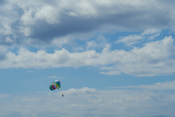 Parasailing. View of parachute pulled by a boat with a sky with clouds in the background.