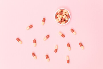 Global Pharmaceutical Industry and Medicinal Products - Colored Pills or Capsules Scattered on Pink Background