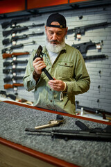Man reload handgun at the counter in gun store