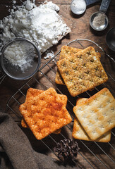 square dry crackers biscuit on a wooden table. wooden texture dark