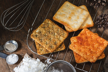 square dry crackers biscuit on a wooden table. wooden texture dark