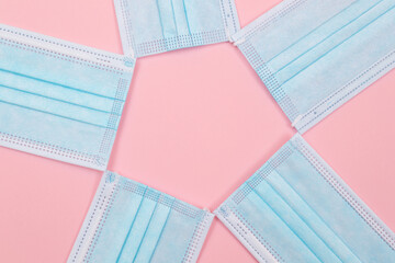 Medical Equipment. Five Disposable Medical Face Masks Lying on Pink Background