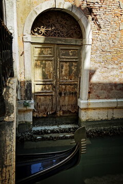 gondola in front of a weathered wooden door in Venice