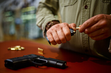 Man loads the magazine with bullets in gun store