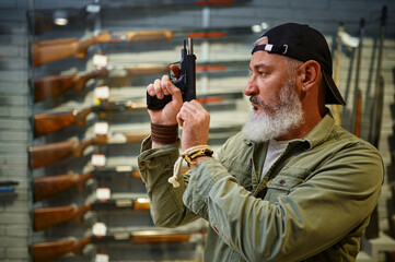 Bearded man twitches the pistol bolt in gun store