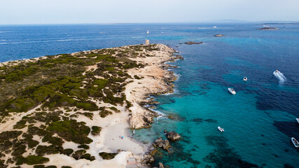 Fototapeta premium Aerial view of Punta de sa Torre de Ses Portes, a sandy point in the south of Ibiza island in Spain with a medieval round defensive tower
