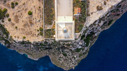 Aerial view of the Far de la Mola, a lighthouse at the southeastern tip of Formentera island in the Balearic, Islands, Spain - White lighthouse at the top of a cliff in the Mediterranean Sea