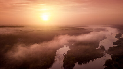 amazing aerial view of foggy morning river and colorful trees. drone shot