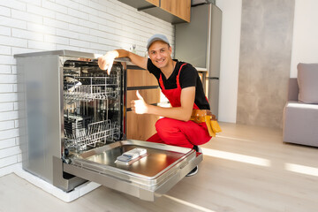 Master installing the dishwasher in a kitchen cabinet
