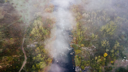 Fototapeta na wymiar amazing aerial view of foggy morning river and colorful trees. drone shot