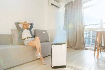 air purifier in living room for clean and fresh air with woman