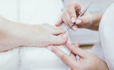 Professional pedicure. Client on medical pedicure procedure. Podiatry clinic. Podology. Healthcare. Close-up. Selective focus. Shallow depth of field.