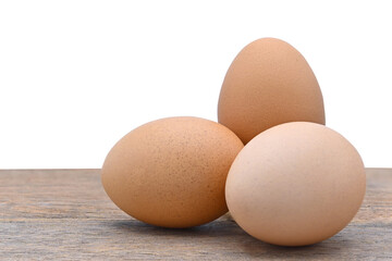 three chicken eggs on old wood and white background close up