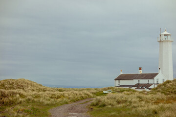 Fototapeta na wymiar Walney Island landscape with the lighhouse, cottage, rugged dune grassland and white space