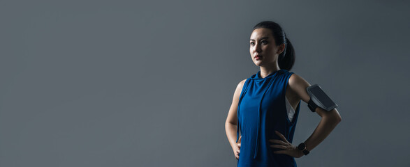 Portrait Asian woman active in sportswear looking to forward posing on web banner grey background. Beautiful female healthy fitness.