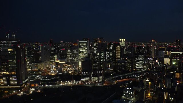 UMEDA, OSAKA, JAPAN : Aerial high angle sunrise view of CITYSCAPE of OSAKA. View of buildings and street around Osaka and Umeda station. Wide view time lapse shot, night to morning.