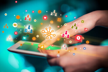 Close-up of a hand using tablet with social media icons