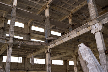 The frame of the building is a close-up with concrete beams with a pile in the foreground.