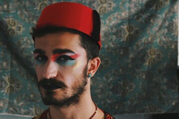 Portrait of queer young man with full face drag makeup & turkish anatolian ottoman traditional clothing with authentic patterns background *4 - obrazy, fototapety, plakaty