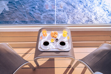 Tasses de café et petit déjeuner sur la terrasse d'une cabine balcon d'un navire de croisière,...