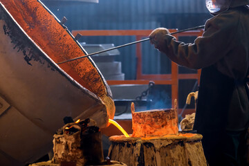 old type working process in a foundry, a worker with a metal brush cleans