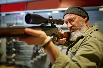 Hunter buying rifle with optical sight, gun store