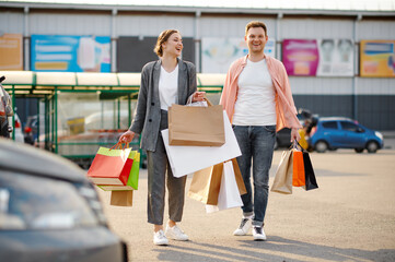 Obraz premium Family couple with bags on supermarket parking