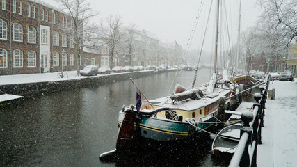 Snowy boat in old harbor city Schiedam