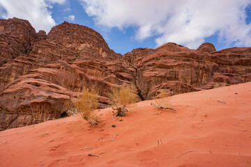 There is a sand dune at the foot of the red relief mountains, the Wadi Rum desert, the nature of Jordan