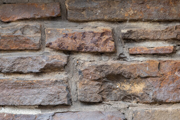 Obraz premium Massive stone wall with rough rocks like a castle wall with different bricks as natural background and rocky wall of ancient times shows solid bricks of stones as vintage texture for granite minerals