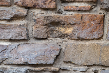 Massive stone wall with rough rocks like a castle wall with different bricks as natural background and rocky wall of ancient times shows solid bricks of stones as vintage texture for granite minerals