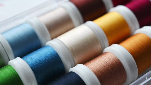 Closeup of selection of colorful threads for sewing machine. Tailoring tools.