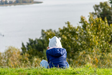 Kid sitting on green slope