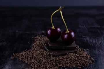 two cherries lying on dark chocolate bars sprinkled with crumbs