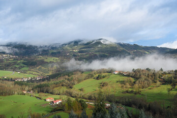 Fototapeta na wymiar Typical landscape of a valley with mist and meadows in the Basque Country