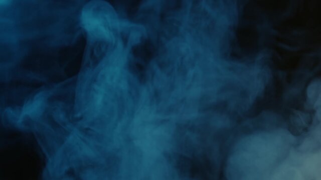 Abstract blue smoke texture with a black backround. An abstract video of moving blue clouds