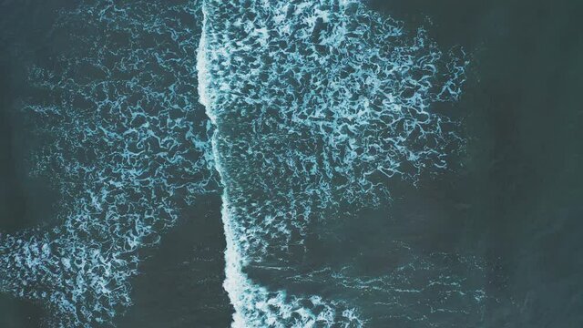 Top down view of sea waves. Aerial view of rolling mass of water leaving patten on surface. Natural abstract background.