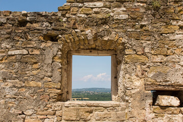 A empty window in a derelict old stone building in the historic medieval village of Buje in Istria,...