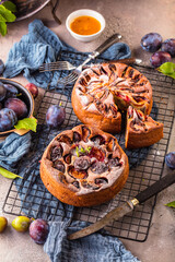 rustic plum cake on dark background , top view