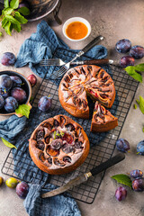 rustic plum cake on dark background , top view
