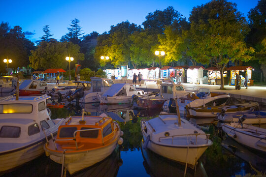 Evening view of Krk Harbor and marina in medieval old town Krk. Mooring yachts, boats and other vessels on the pier. A summer vacation in a Croatian islands at Adriatic sea. Island Krk, Croatia.